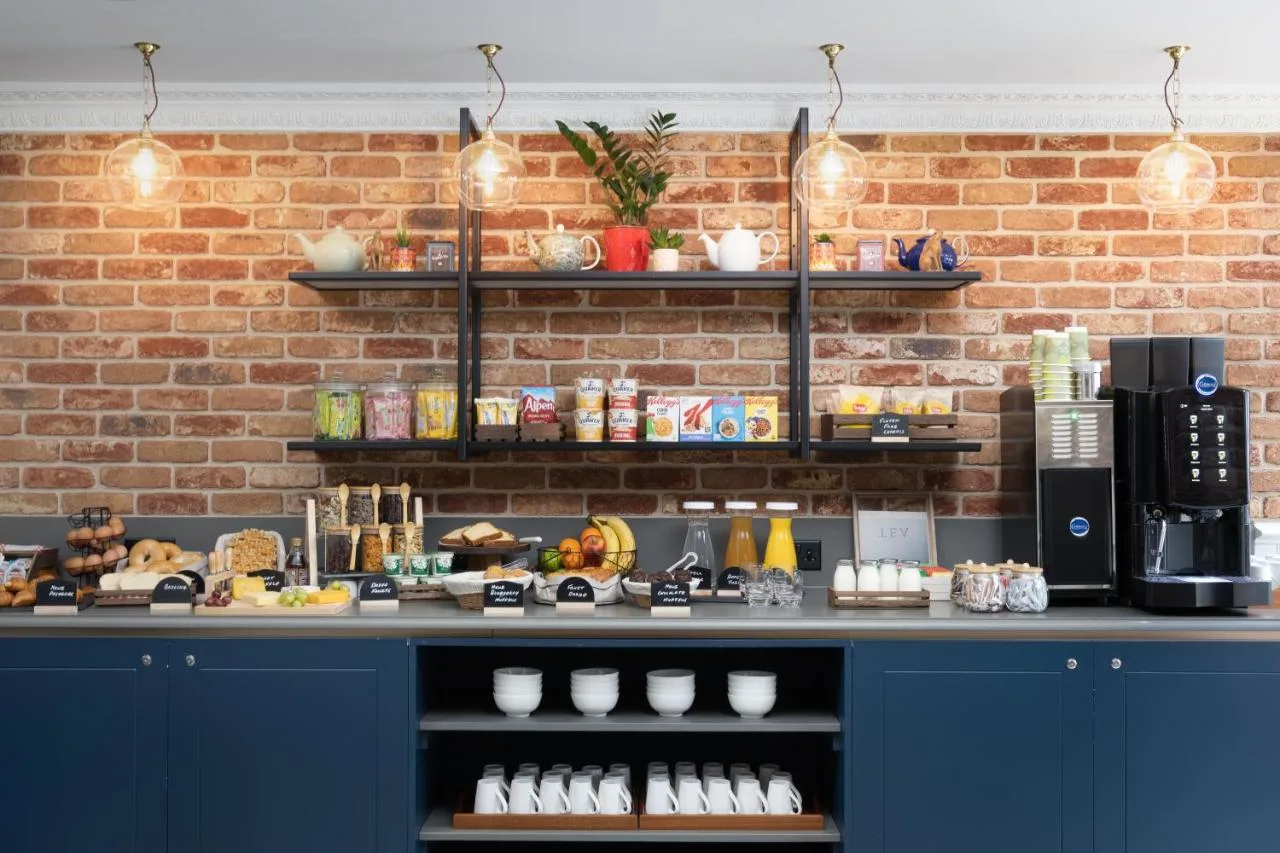 a counter in a coffee shop with a brick wall at The 55 by Le Mirage in London